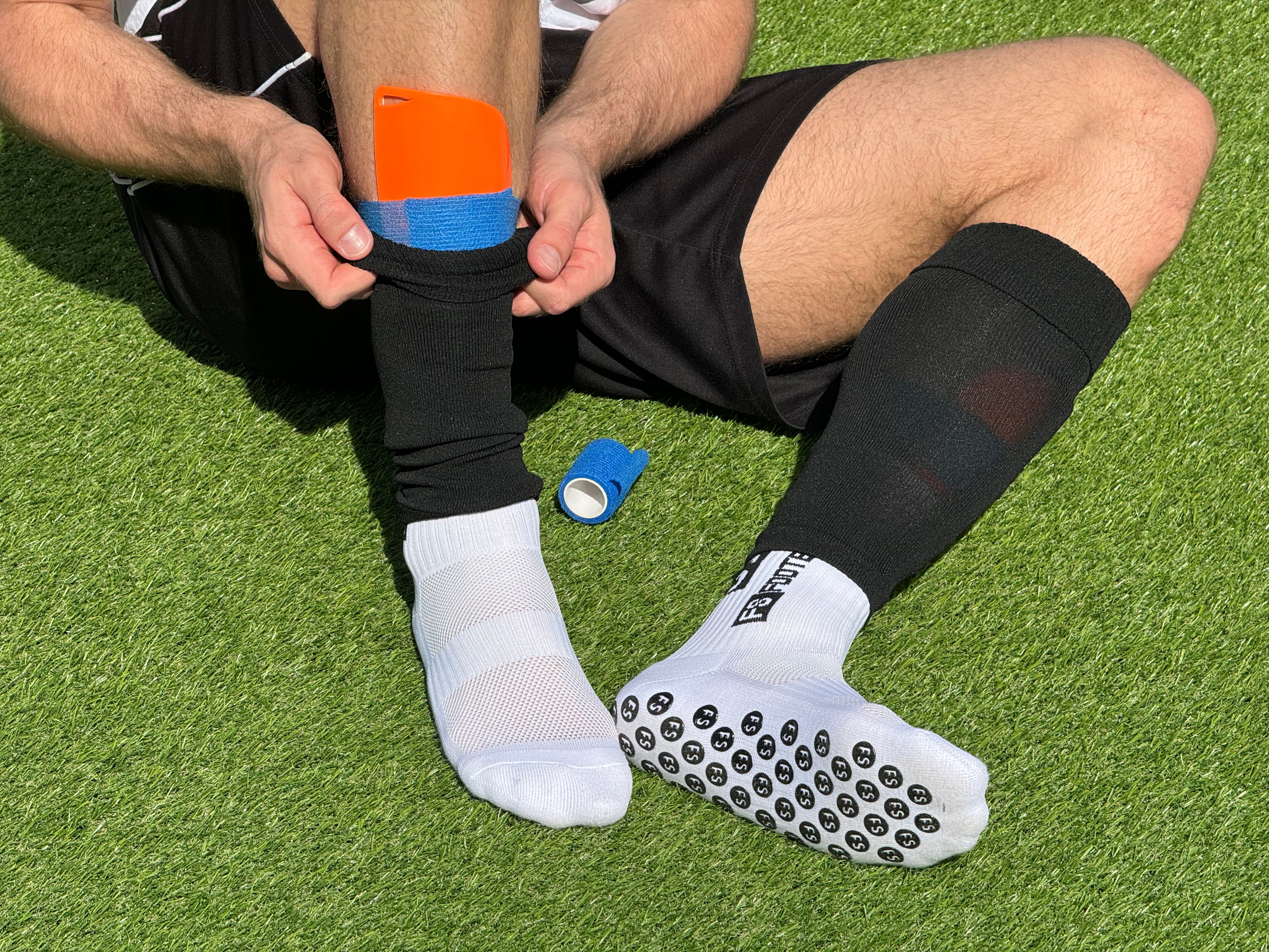 Weisse FS Footballsocks Originals Grip Socken auf Kunstrasen mit schwarzen FS Tubes und blauen FS Bandages